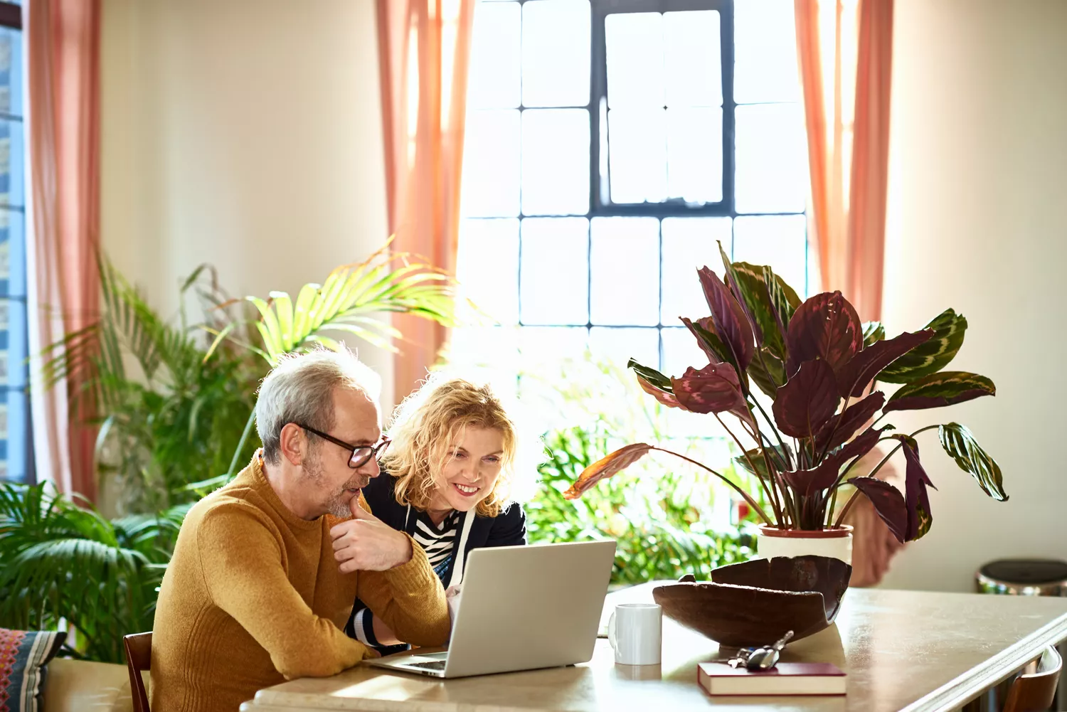 Excited mature woman looking at laptop with her husband