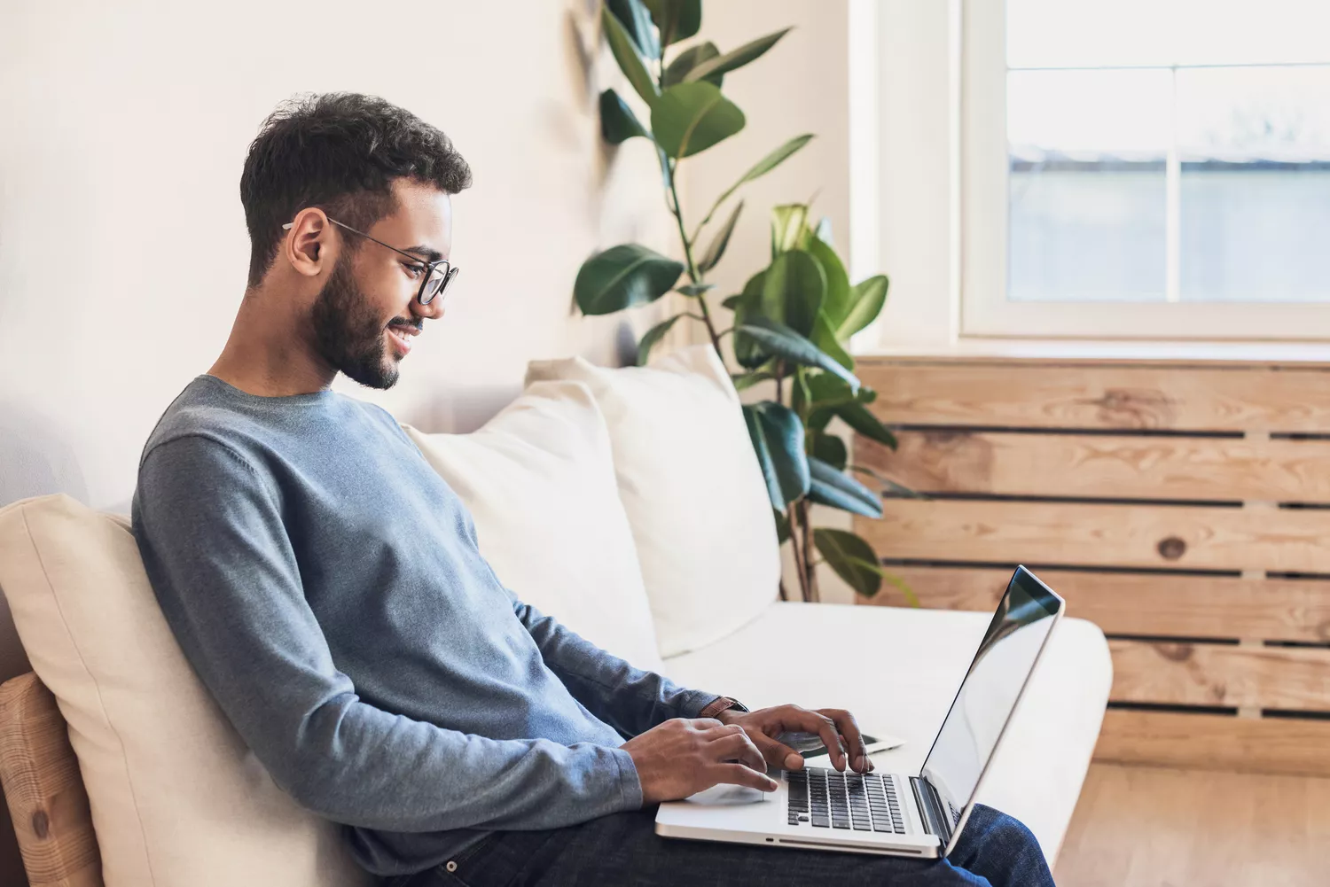 Bespectacled man working on a laptop